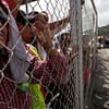 Panama Canal workers look on from behind a fence as strike enters day number 2