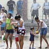 A Panamanian family cools off in the water spray along the Cinta Costera during the second day of Carnival 2012 in Panama