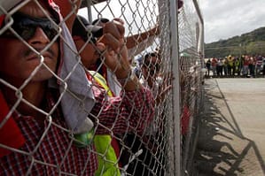 Panama Canal workers look on from behind a fence as strike enters day number 2